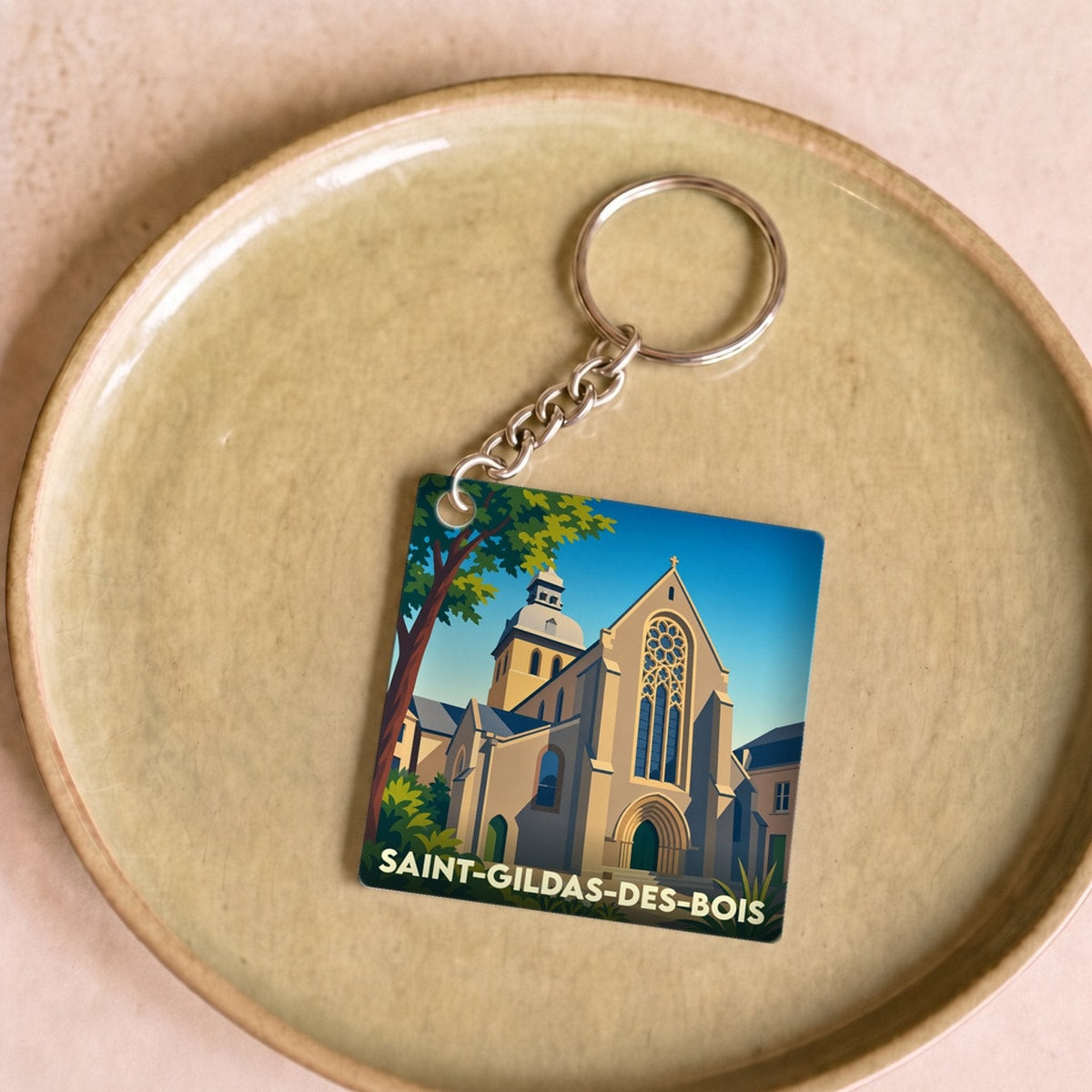 Porte-clés souvenir de la ville de Saint-Gildas-des-Bois avec une illustration stylisée de son église.