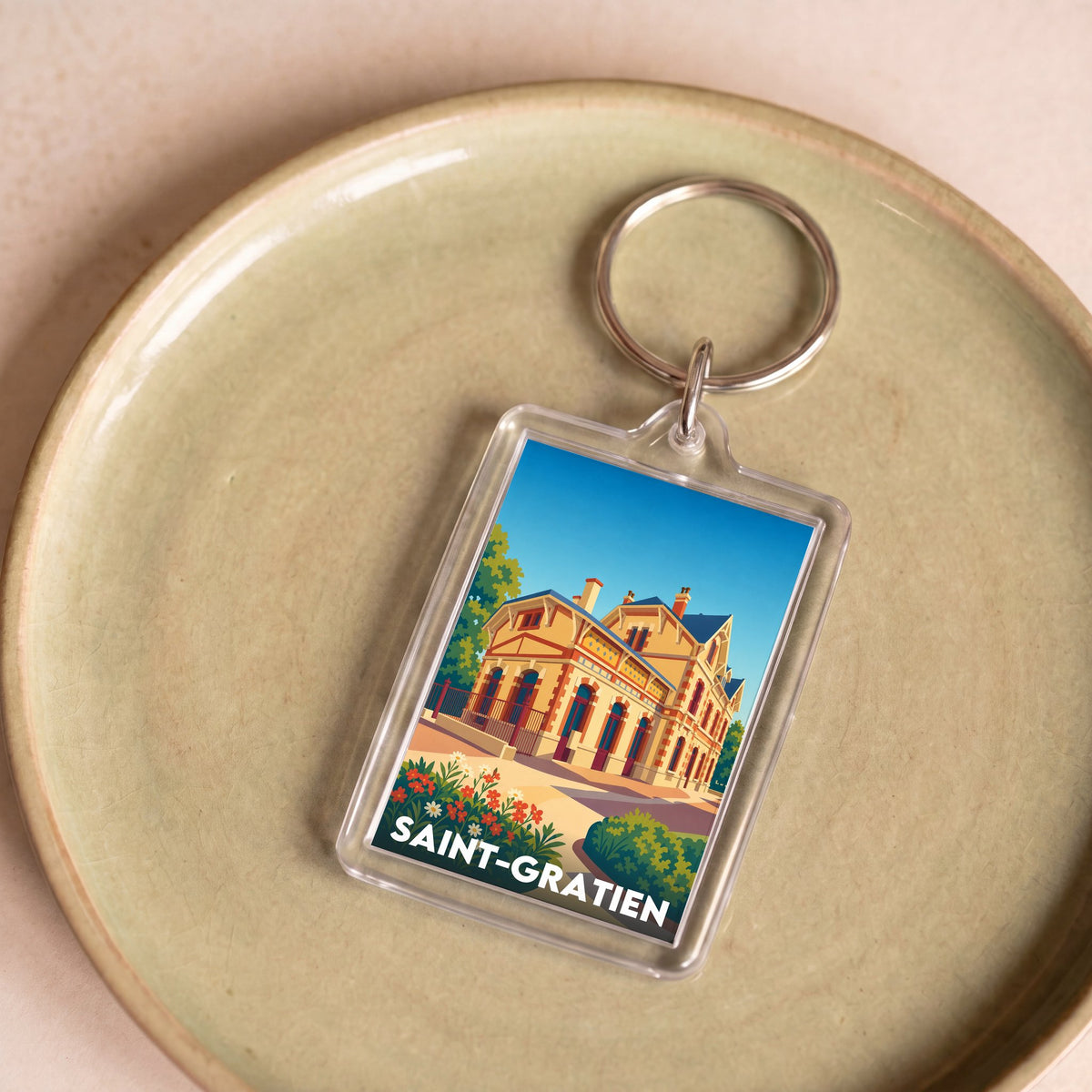 Porte-clés souvenir de la ville de Saint-Gratien avec une illustration stylisée.