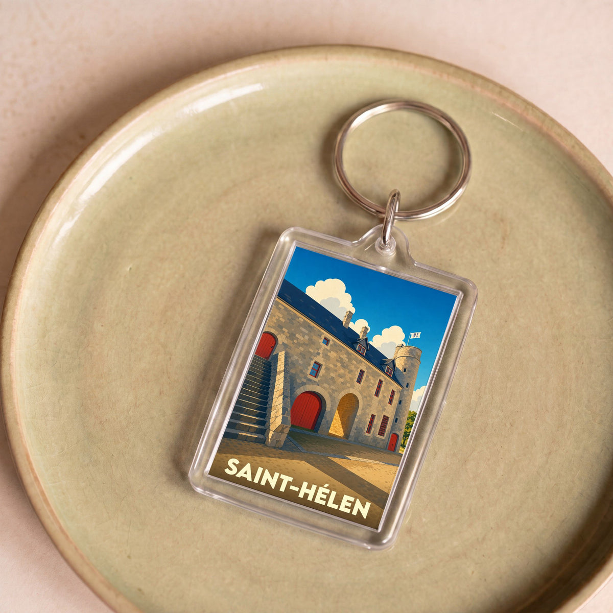 Porte-clés souvenir de la ville de Saint-Hélen avec une illustration stylisée de son patrimoine en pierre.