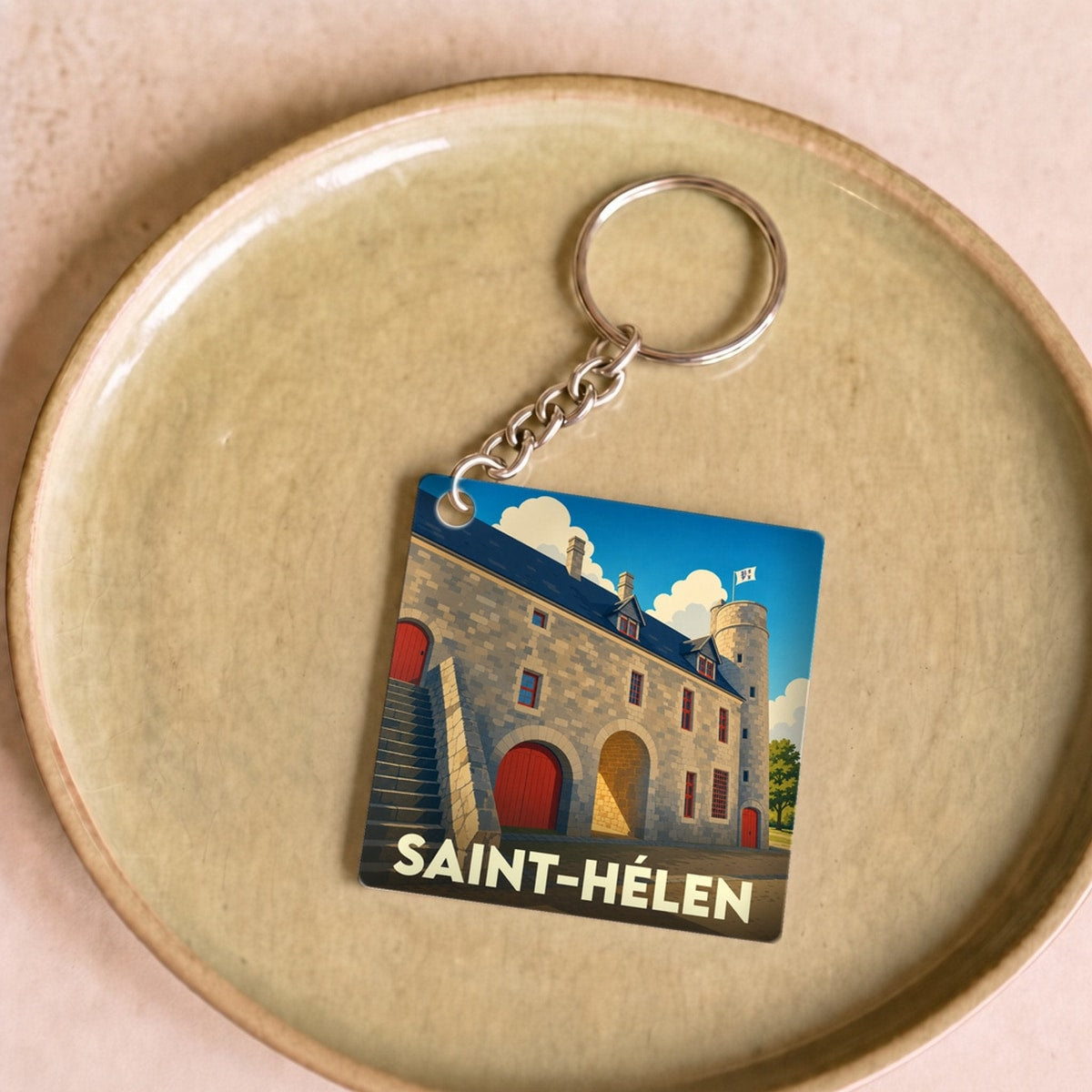 Porte-clés souvenir de la ville de Saint-Hélen avec une illustration stylisée de son patrimoine en pierre.