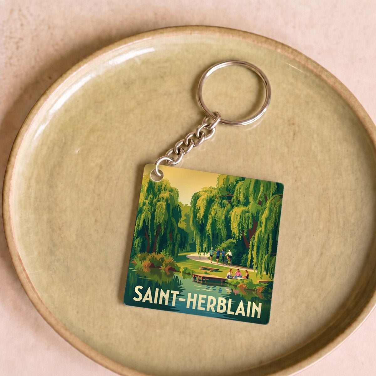 Porte-clés souvenir de la ville de Saint-Herblain avec une illustration stylisée.