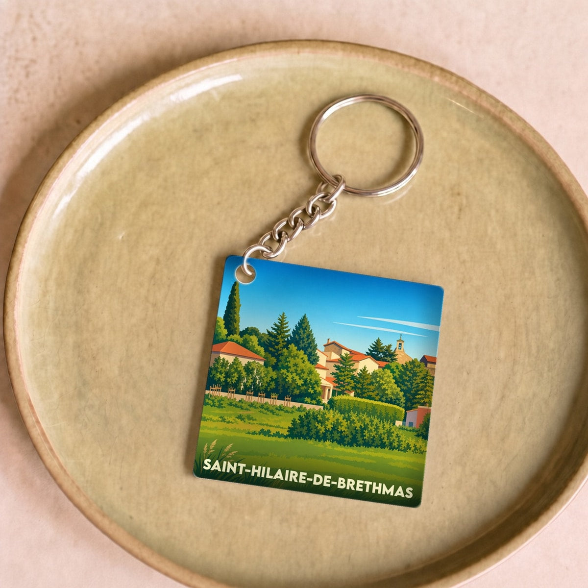 Porte-clés souvenir de la ville de Saint-Hilaire-de-Brethmas avec une illustration stylisée.