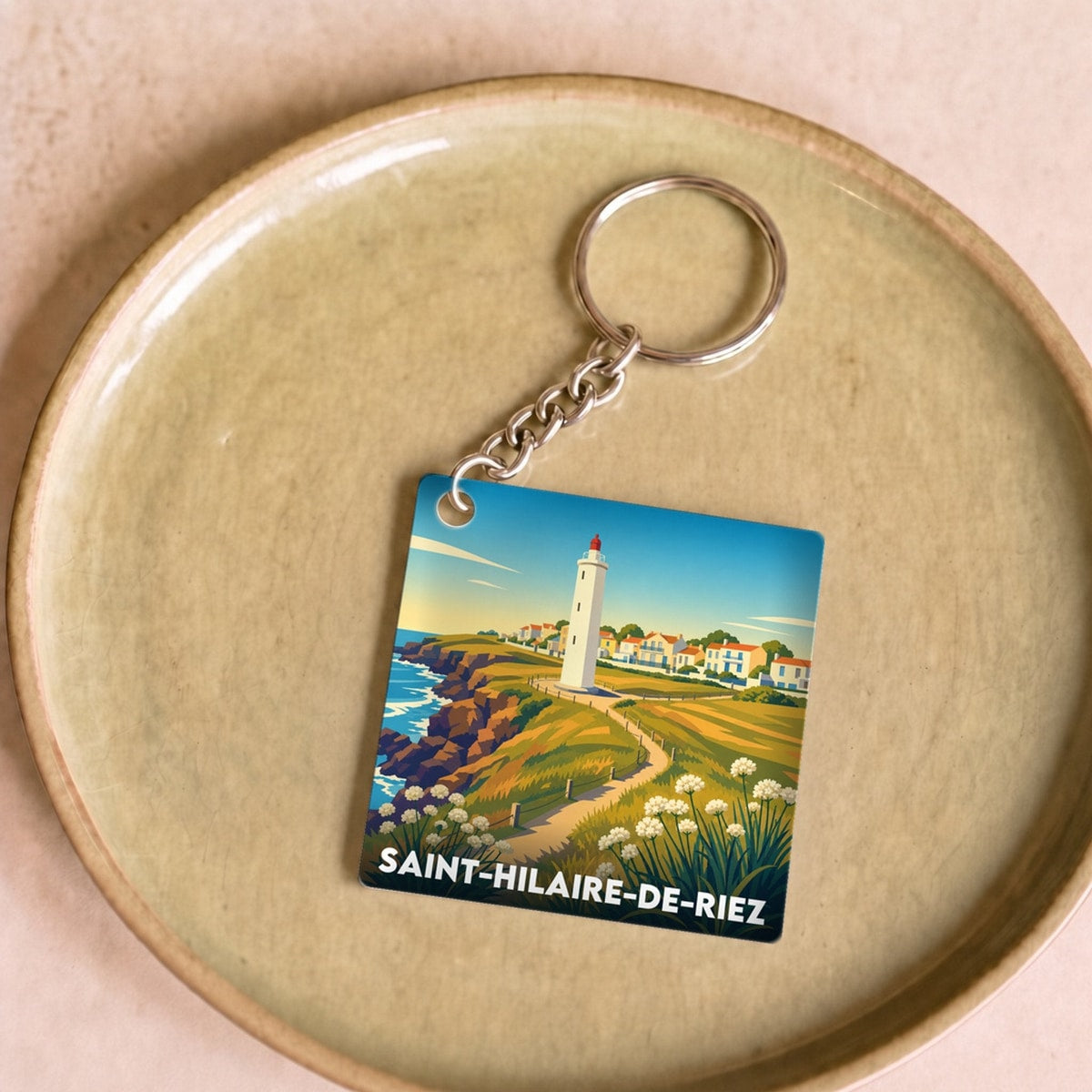 Porte-clés souvenir de la ville de Saint-Hilaire-de-Riez avec une illustration stylisée d'un paysage côtier.