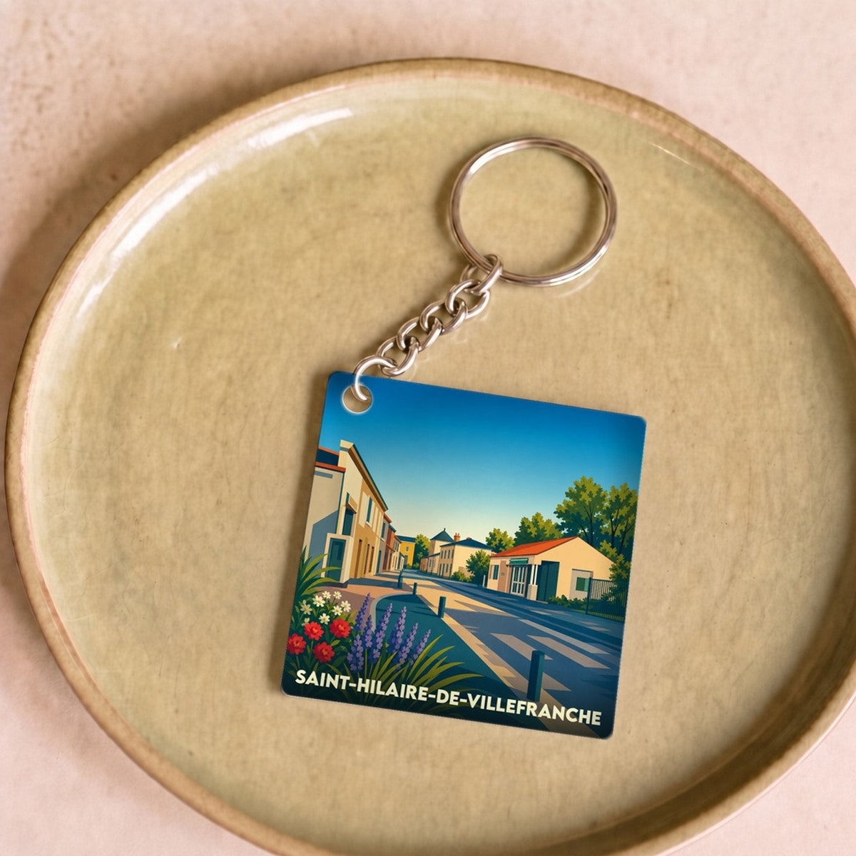 Porte-clés souvenir de la ville de Saint-Hilaire-de-Villefranche avec une illustration stylisée.