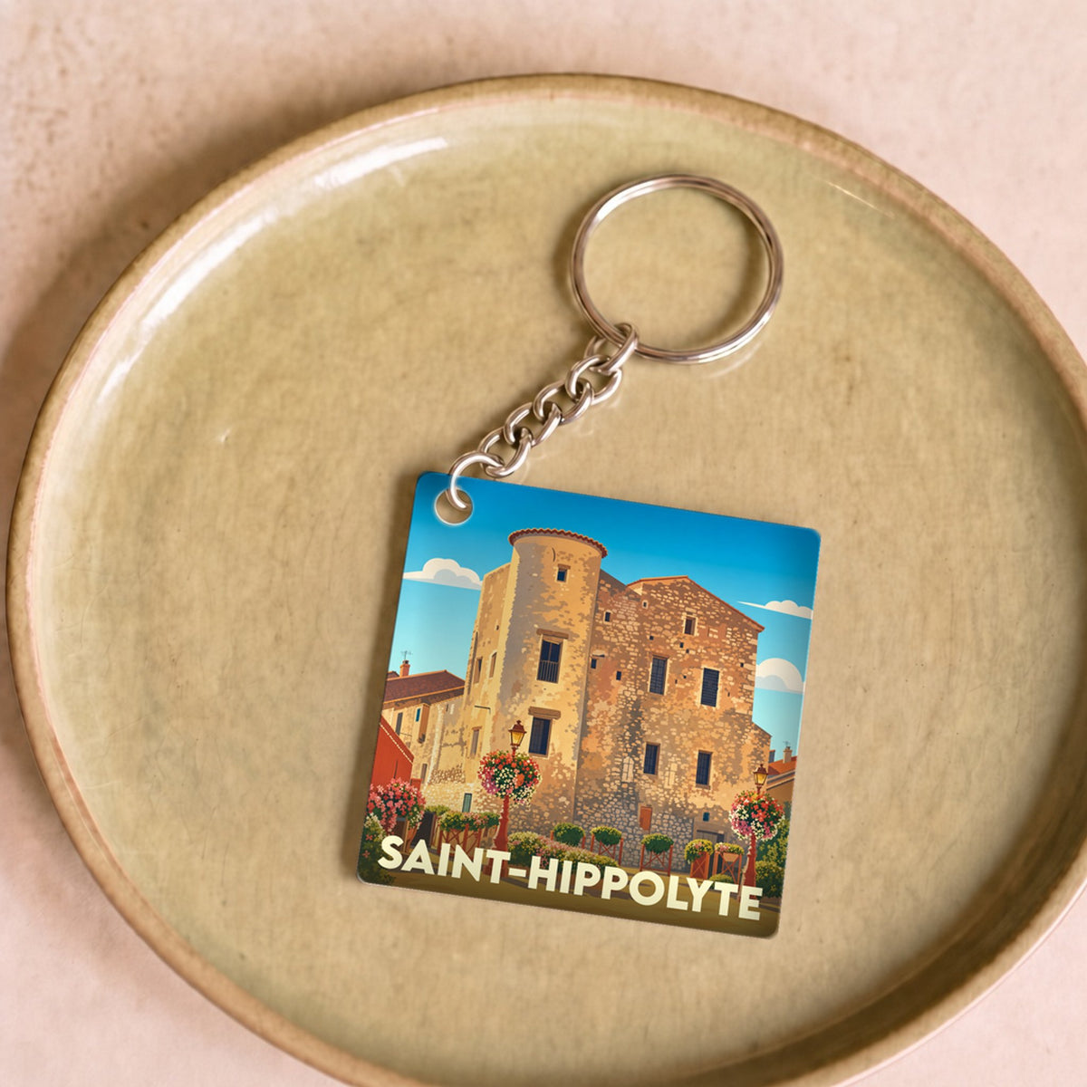 Porte-clés souvenir de la ville de Saint-Hippolyte avec une illustration stylisée.