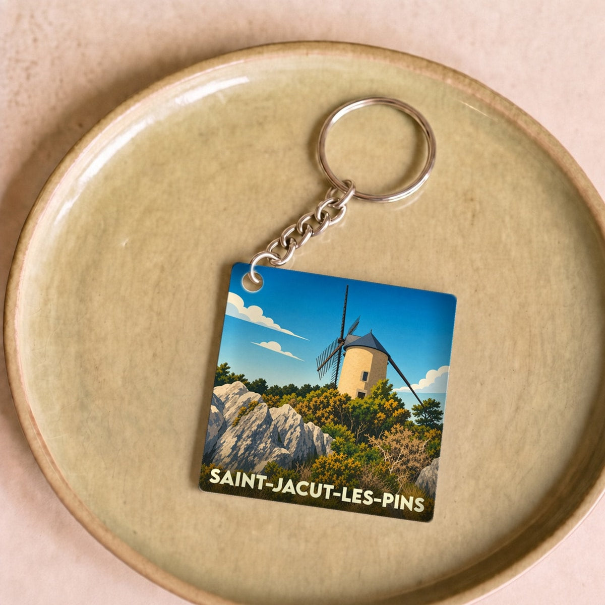 Porte-clés souvenir de la ville de Saint-Jacut-les-Pins avec une illustration stylisée d'un moulin.