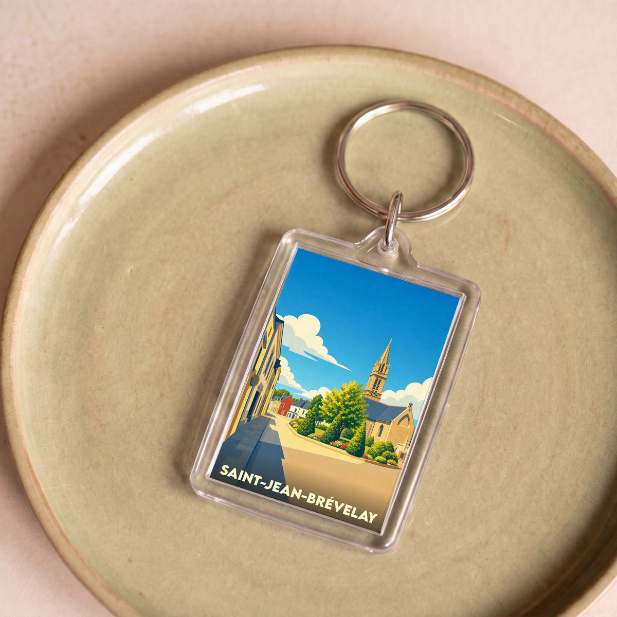 Porte-clés souvenir de la ville de Saint-Jean-Brévelay avec une illustration stylisée.