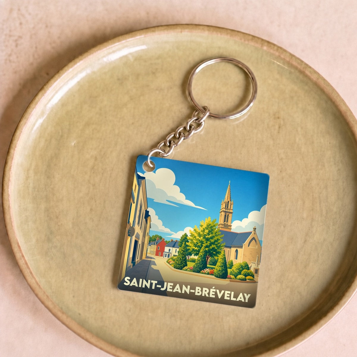 Porte-clés souvenir de la ville de Saint-Jean-Brévelay avec une illustration stylisée.