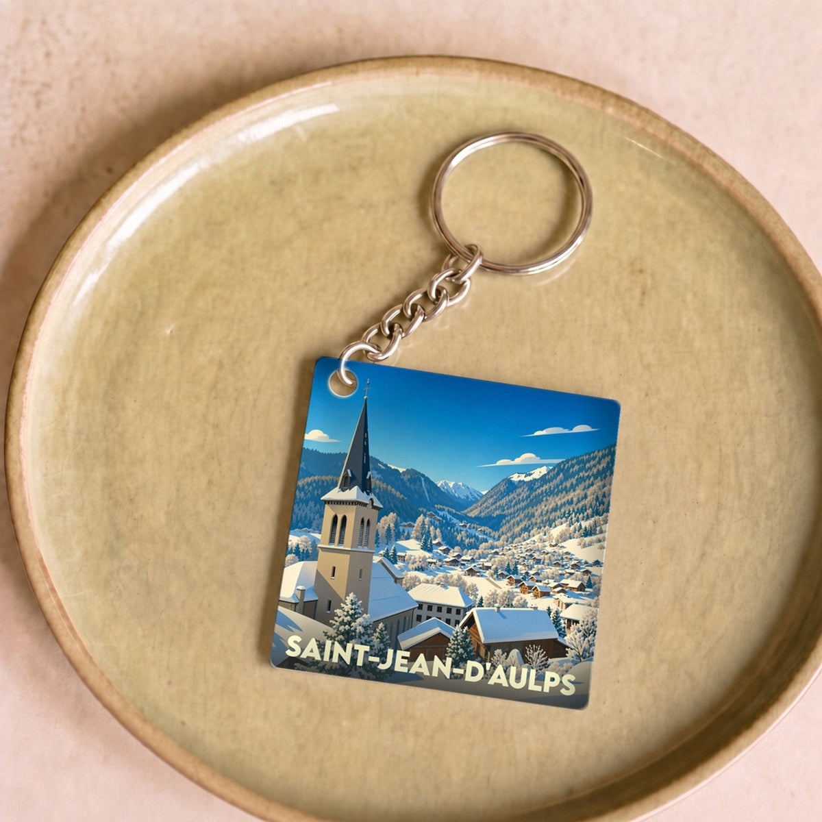 Porte-clés souvenir de la ville de Saint-Jean-d'Aulps avec une illustration hivernale stylisée.