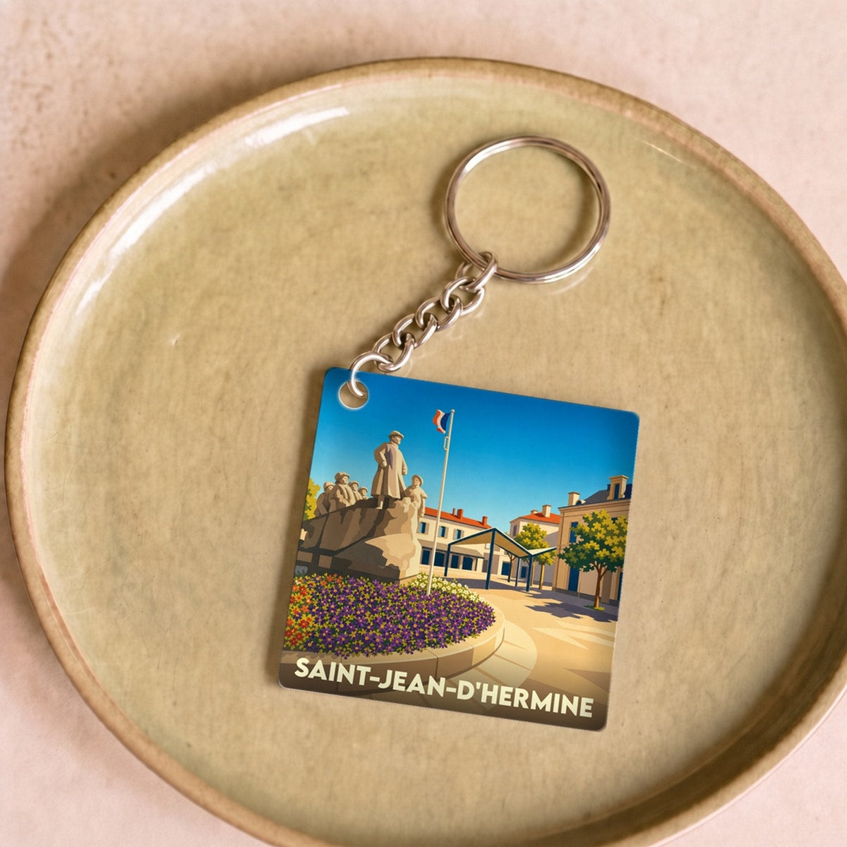 Porte-clés souvenir de la ville de Saint-Jean-d'Hermine avec une illustration stylisée de son monument.
