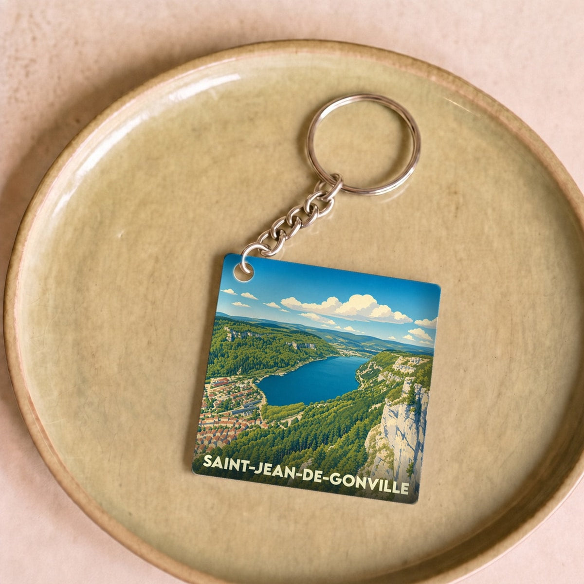 Porte-clés souvenir de la ville de Saint-Jean-de-Gonville avec une illustration stylisée de ses paysages naturels.