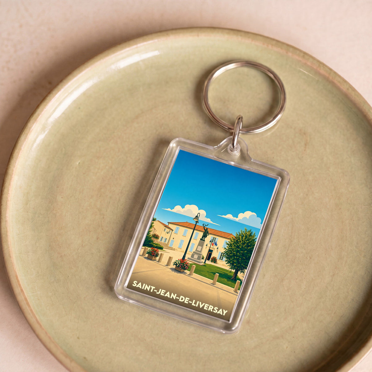 Porte-clés souvenir de la ville de Saint-Jean-de-Liversay avec une illustration stylisée.