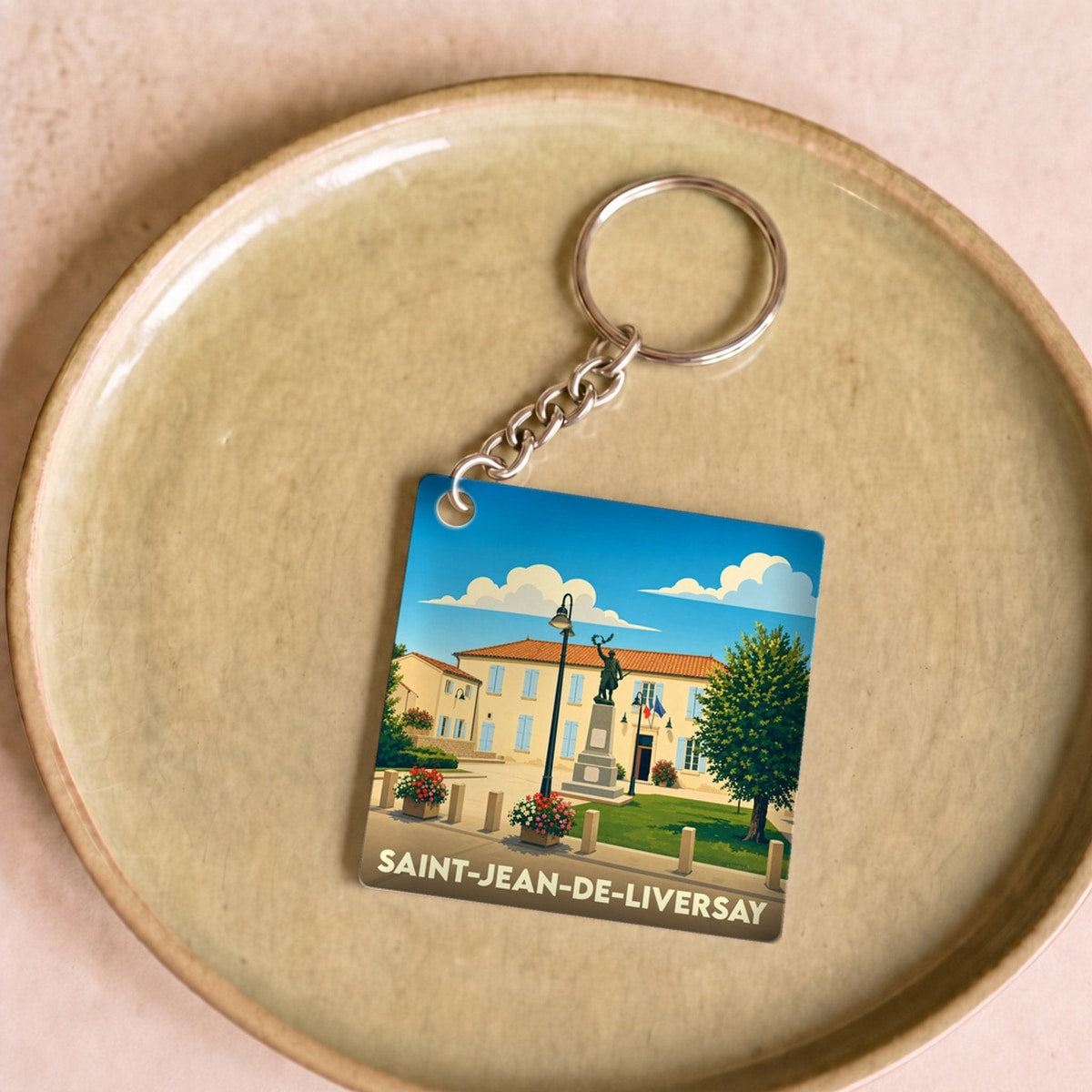 Porte-clés souvenir de la ville de Saint-Jean-de-Liversay avec une illustration stylisée.