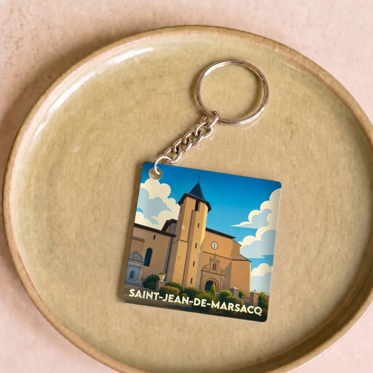 Porte-clés souvenir de la ville de Saint-Jean-de-Marsacq avec une illustration stylisée de son église.