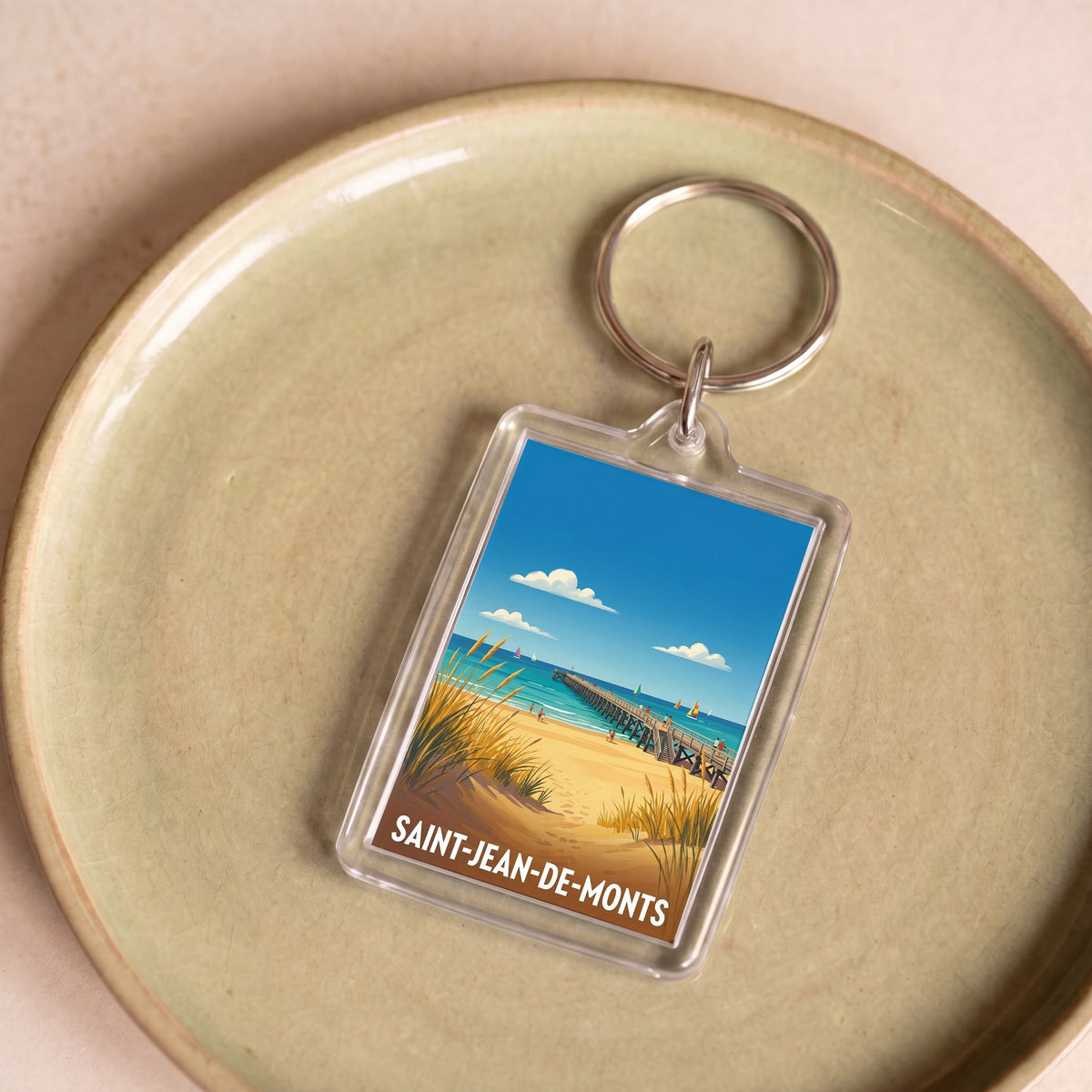 Porte-clés souvenir de la ville de Saint-Jean-de-Monts avec une illustration stylisée de son bord de mer.