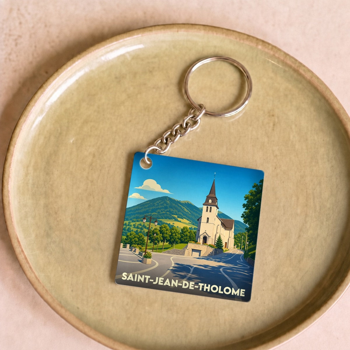 Porte-clés souvenir de la ville de Saint-Jean-de-Tholome avec une illustration stylisée de son église.