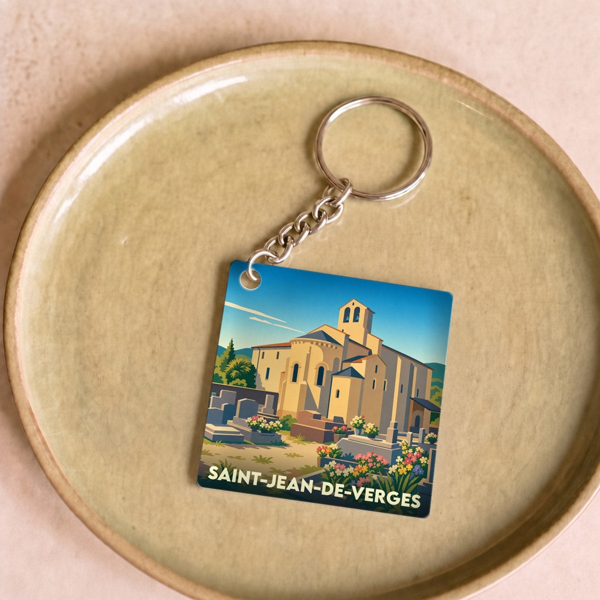 Porte-clés souvenir de la ville de Saint-Jean-de-Verges avec une illustration stylisée de son église romane.
