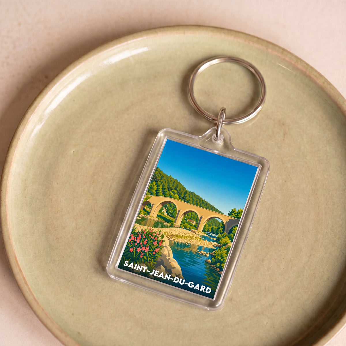 Porte-clés souvenir de la ville de Saint-Jean-du-Gard avec une illustration stylisée.