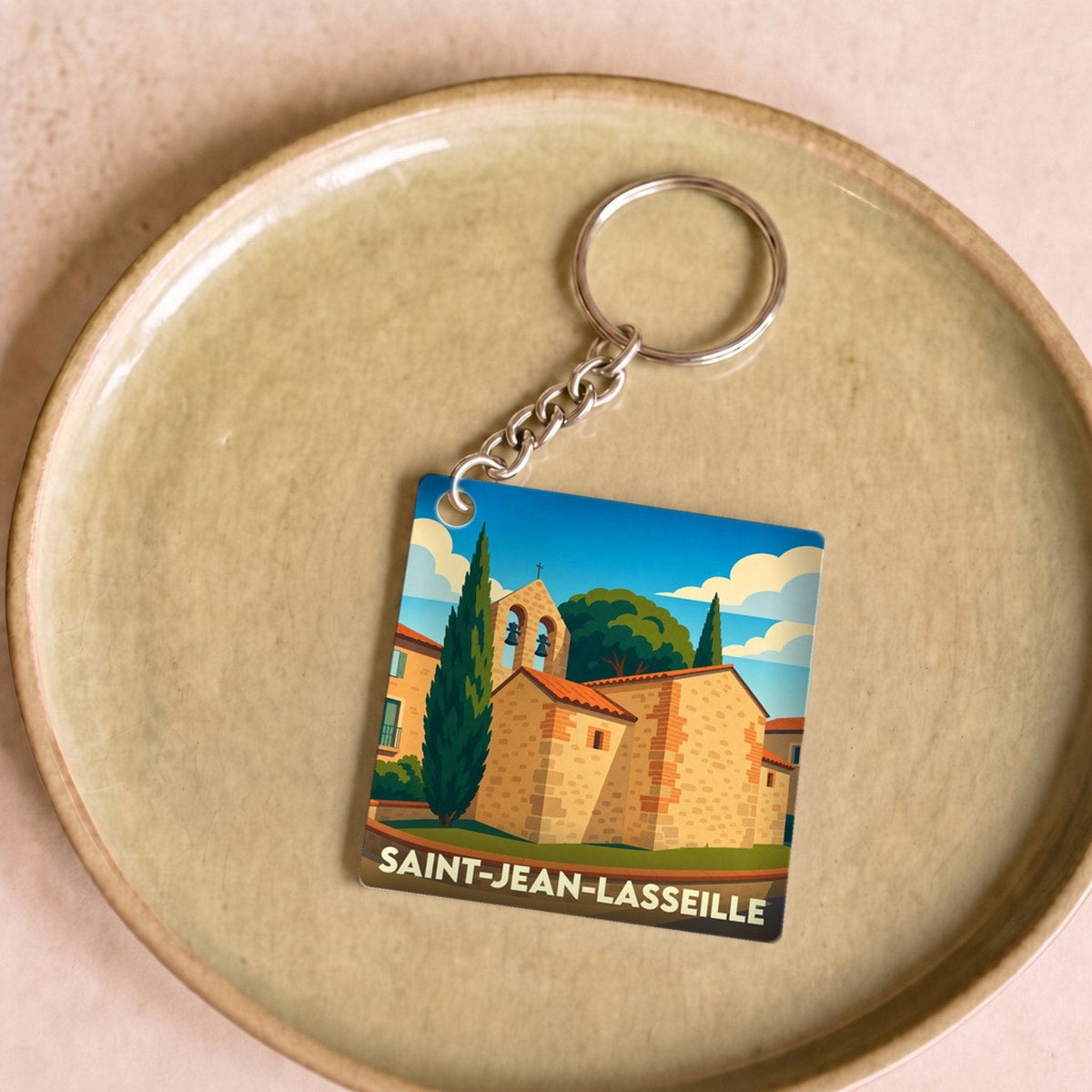 Porte-clés souvenir de la ville de Saint-Jean-Lasseille avec une illustration stylisée de son église.