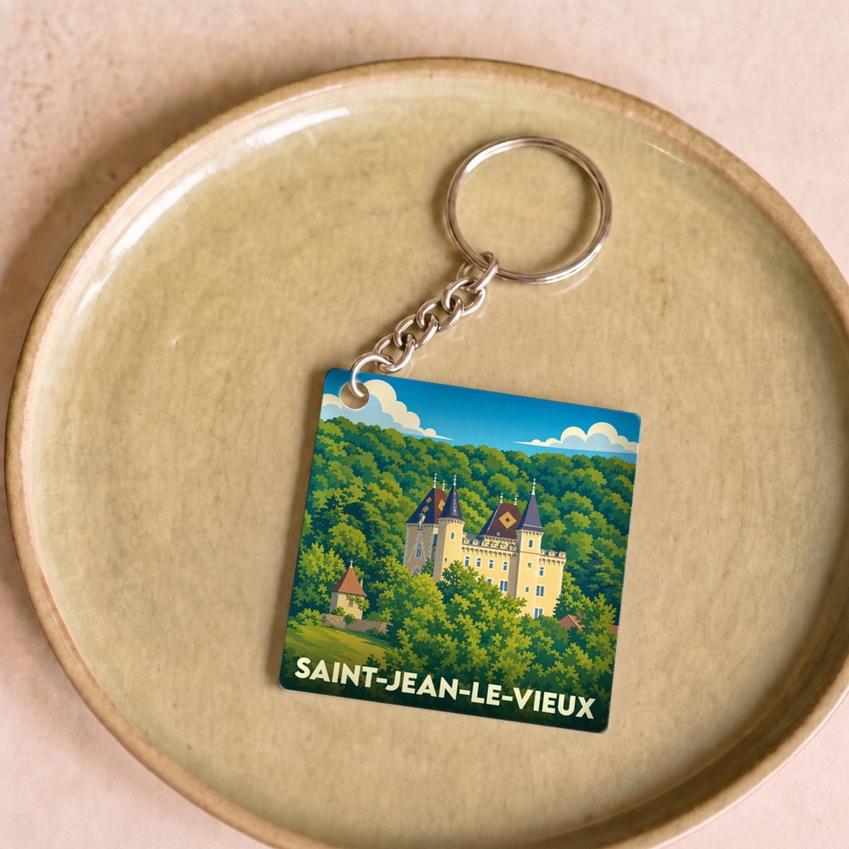 Porte-clés souvenir de la ville de Saint-Jean-le-Vieux avec une illustration stylisée de son château.