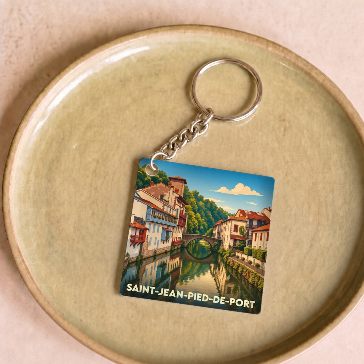 Porte-clés souvenir de la ville de Saint-Jean-Pied-de-Port avec une illustration stylisée.