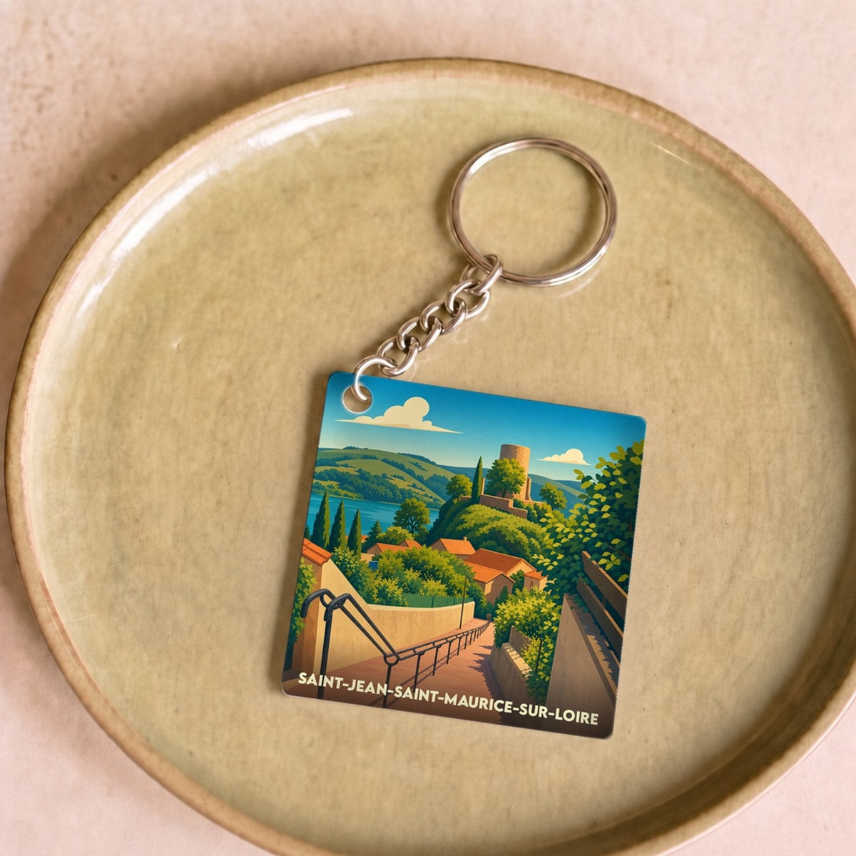 Porte-clés souvenir de la ville de Saint-Jean-Saint-Maurice-sur-Loire avec une illustration stylisée de son village médiéval.