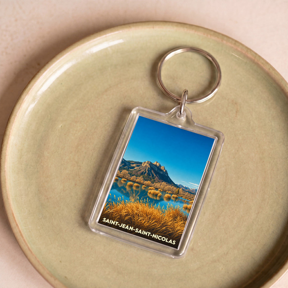 Porte-clés souvenir de la ville de Saint-Jean-Saint-Nicolas avec une photo de paysage de montagne et de lac.
