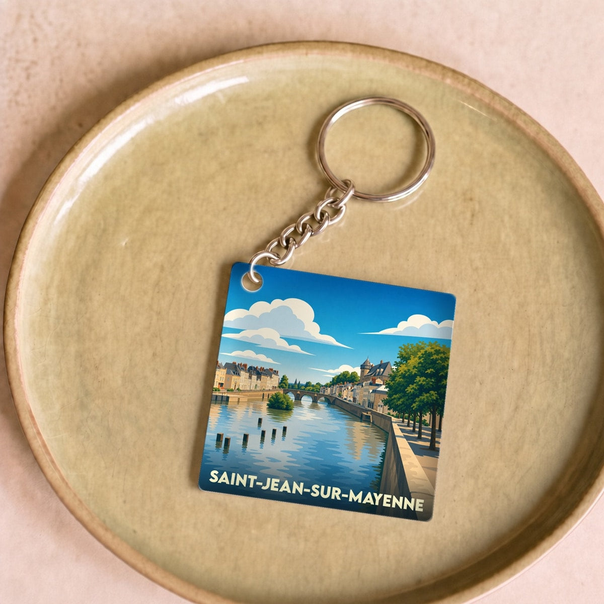 Porte-clés souvenir de la ville de Saint-Jean-sur-Mayenne avec une illustration stylisée des bords de la Mayenne.