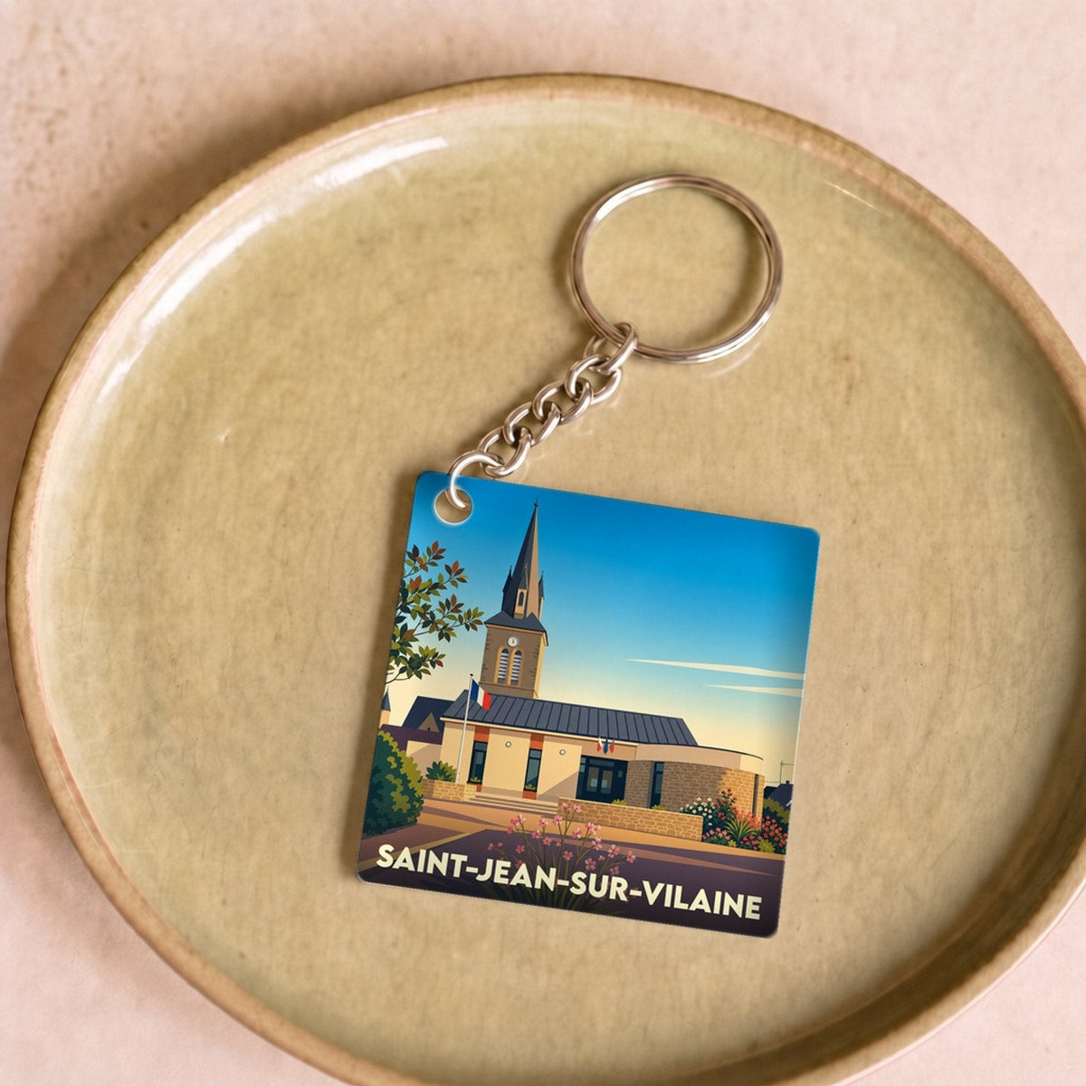 Porte-clés souvenir de Saint-Jean-sur-Vilaine avec une illustration stylisée de sa mairie et de son église.