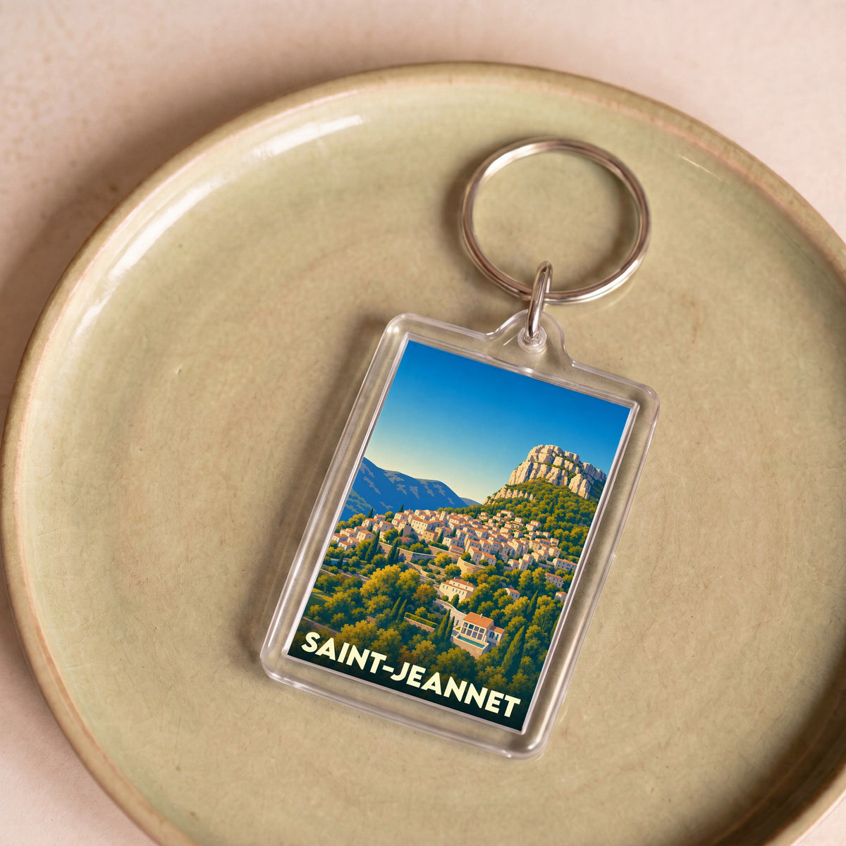 Porte-clés souvenir de la ville de Saint-Jeannet avec une illustration stylisée du village et de son célèbre baou.