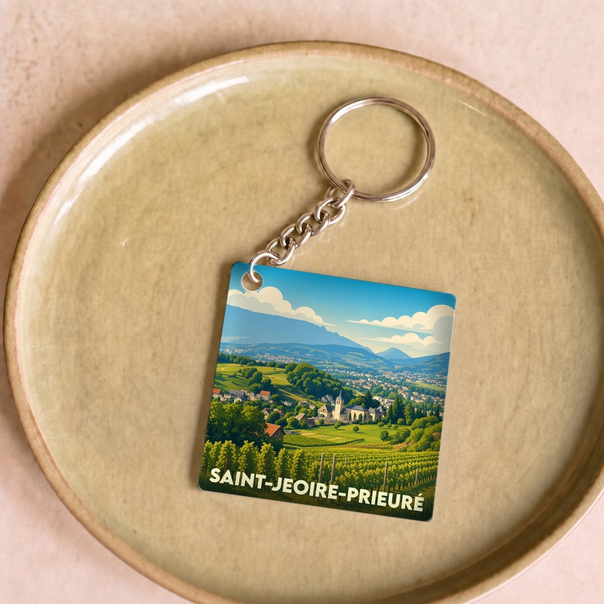 Porte-clés souvenir de la ville de Saint-Jeoire-Prieuré avec une illustration stylisée de ses vignobles et montagnes.