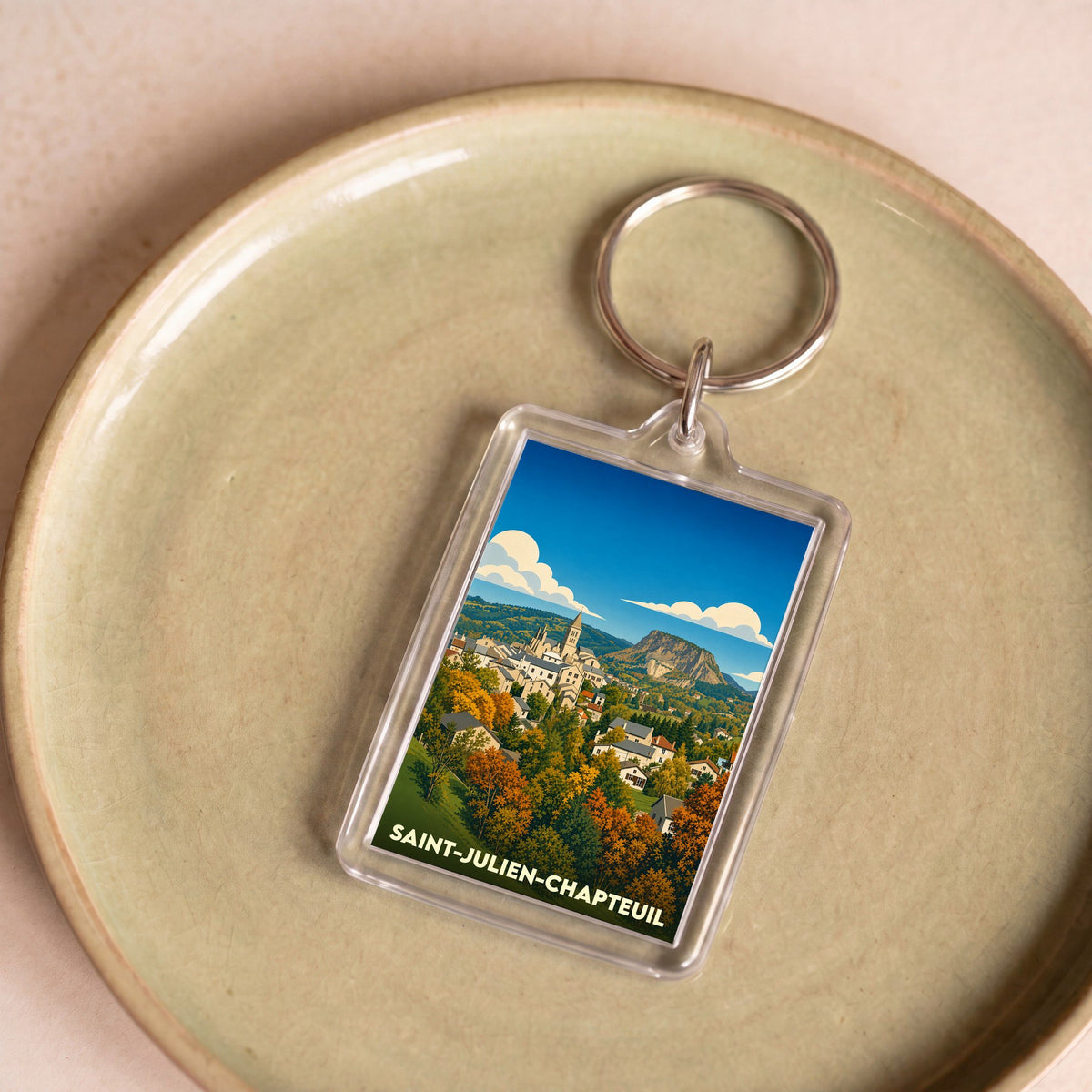 Porte-clés souvenir de la ville de Saint-Julien-Chapteuil avec une illustration paysagère stylisée.