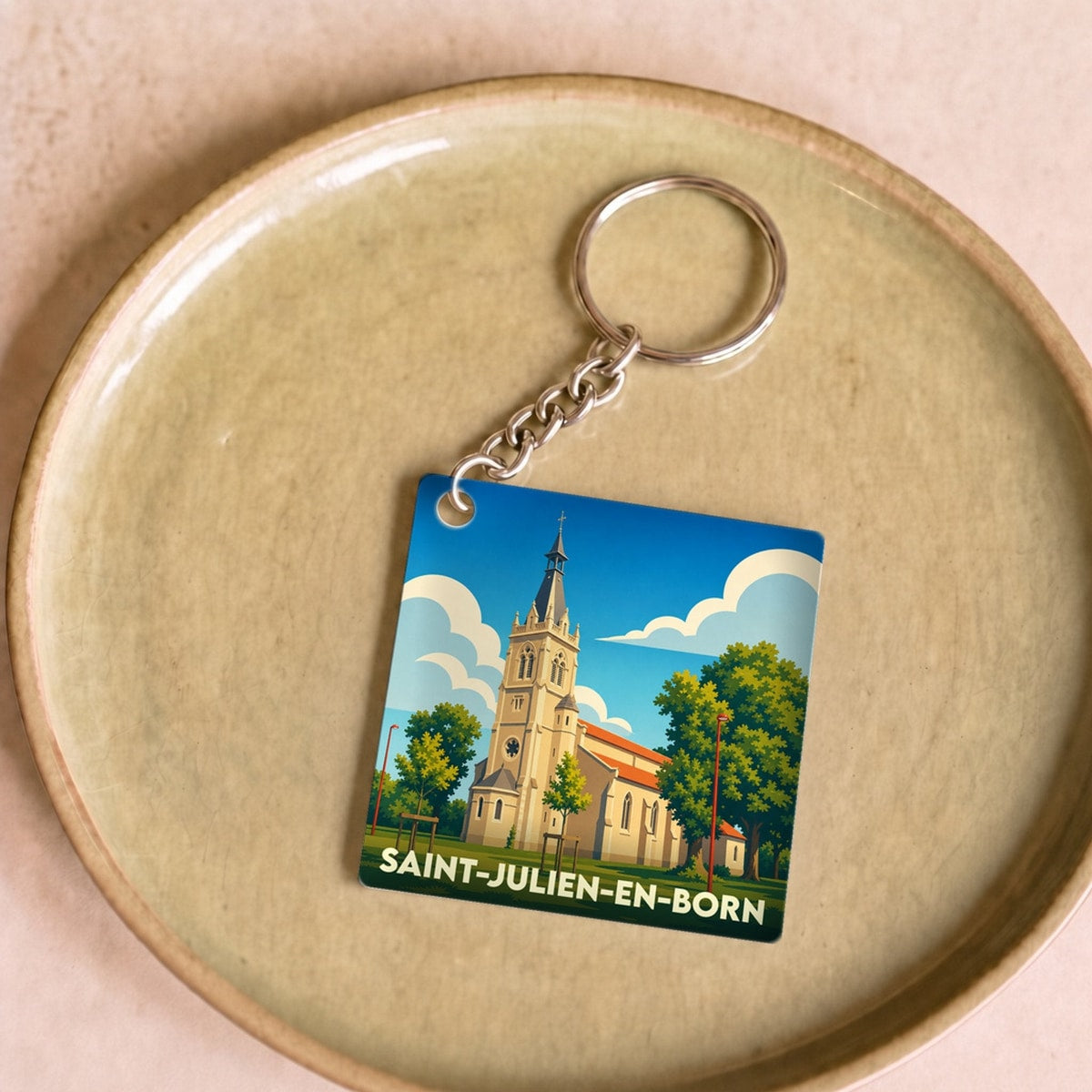 Porte-clés souvenir de la ville de Saint-Julien-en-Born avec une illustration stylisée de son église.