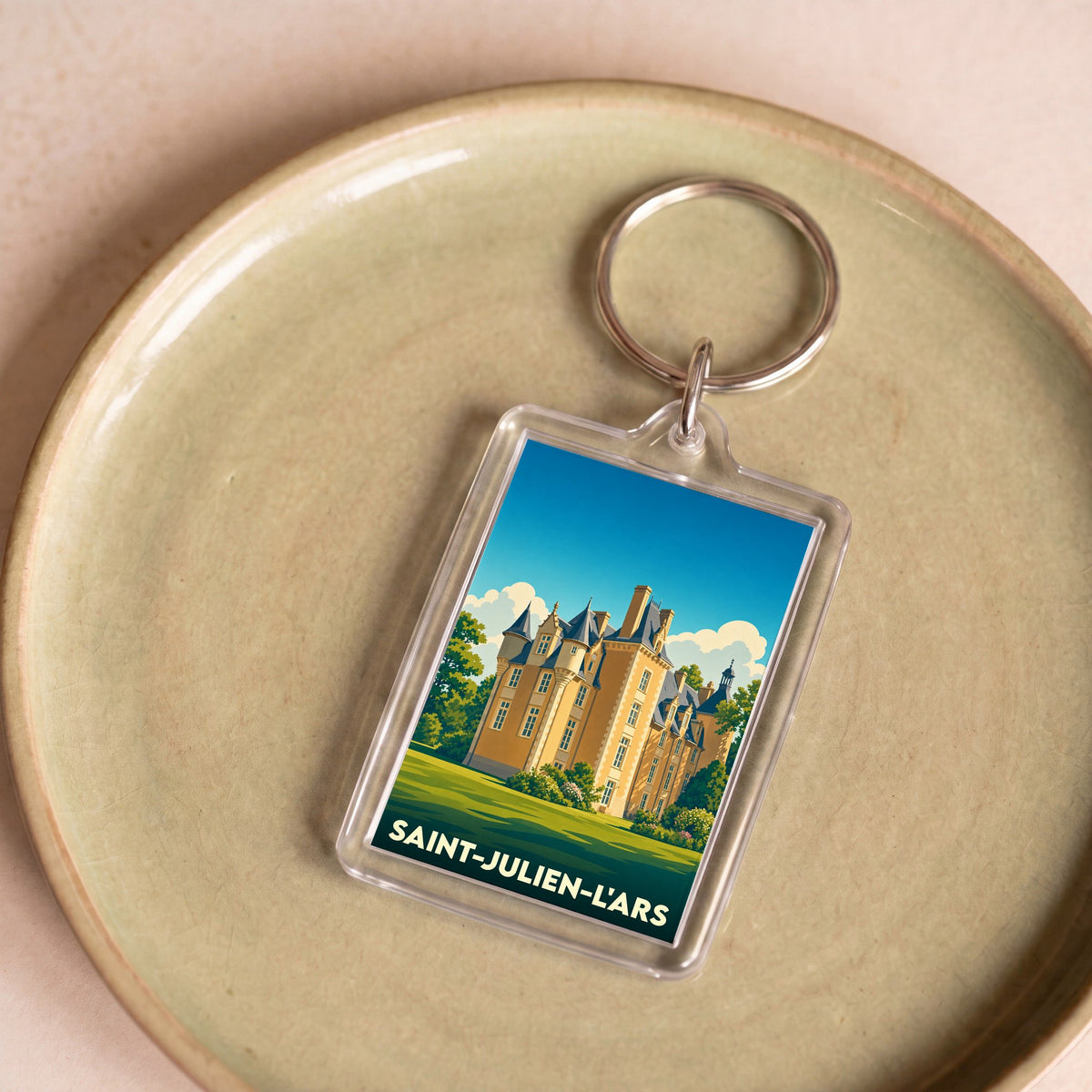 Porte-clés souvenir de la ville de Saint-Julien-l'Ars avec une illustration stylisée de son château.