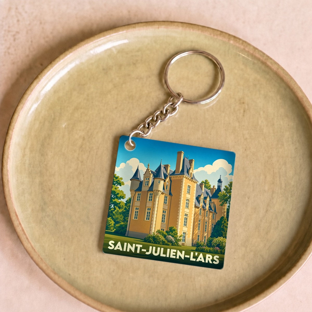 Porte-clés souvenir de la ville de Saint-Julien-l'Ars avec une illustration stylisée de son château.