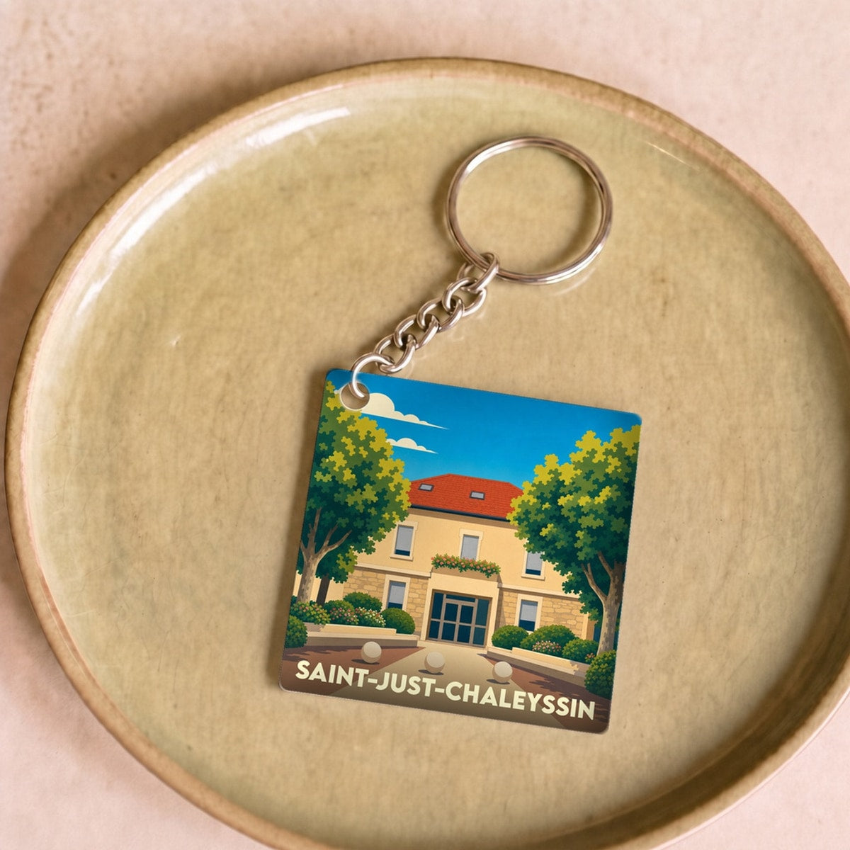Porte-clés souvenir de la ville de Saint-Just-Chaleyssin avec une illustration stylisée.