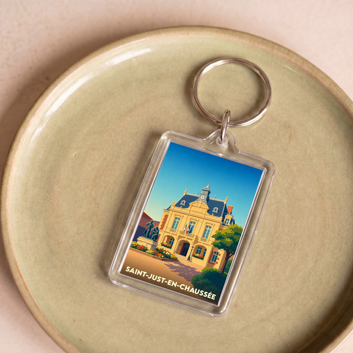 Porte-clés souvenir de la ville de Saint-Just-en-Chaussée avec une illustration stylisée de son hôtel de ville.