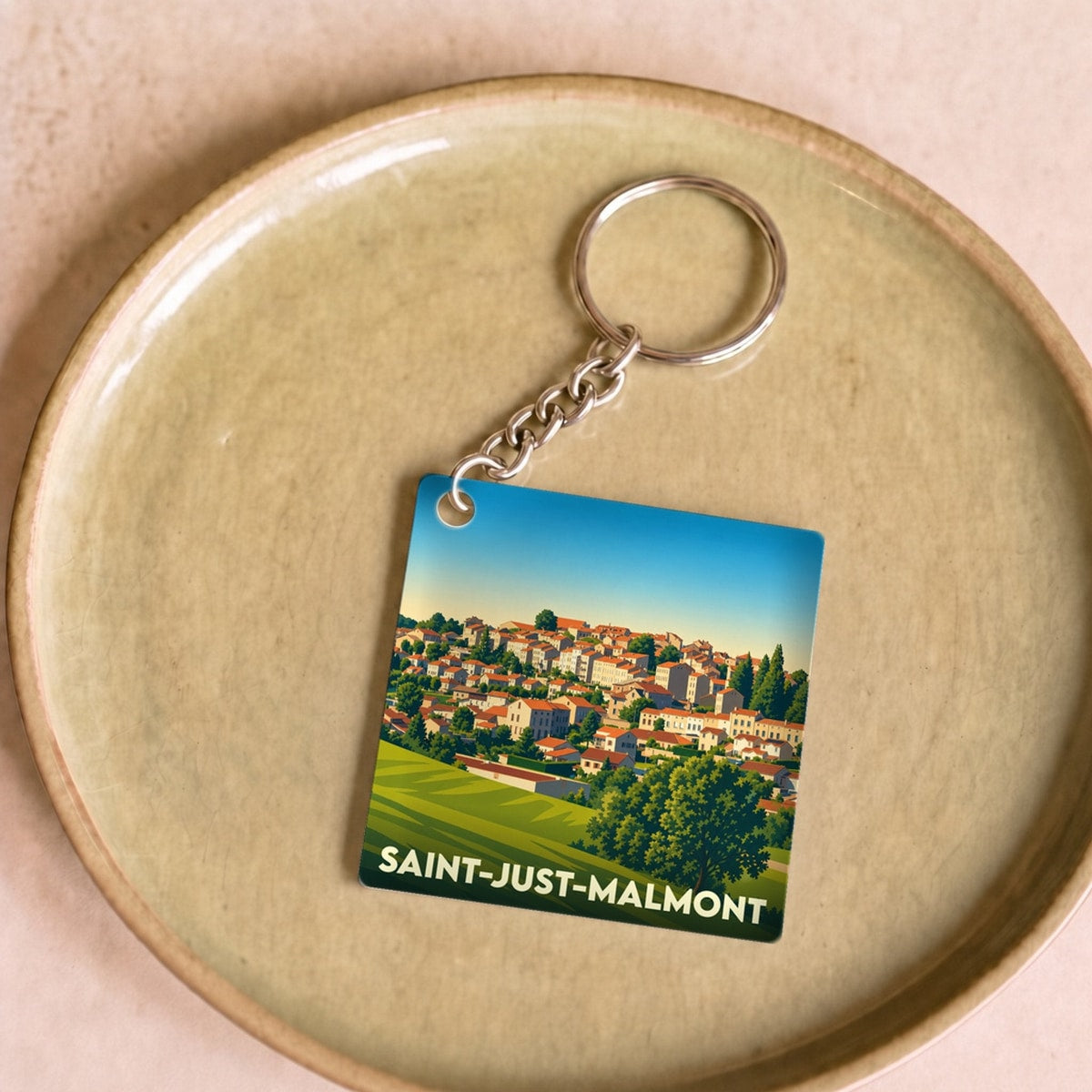 Porte-clés souvenir de la ville de Saint-Just-Malmont avec une illustration stylisée.