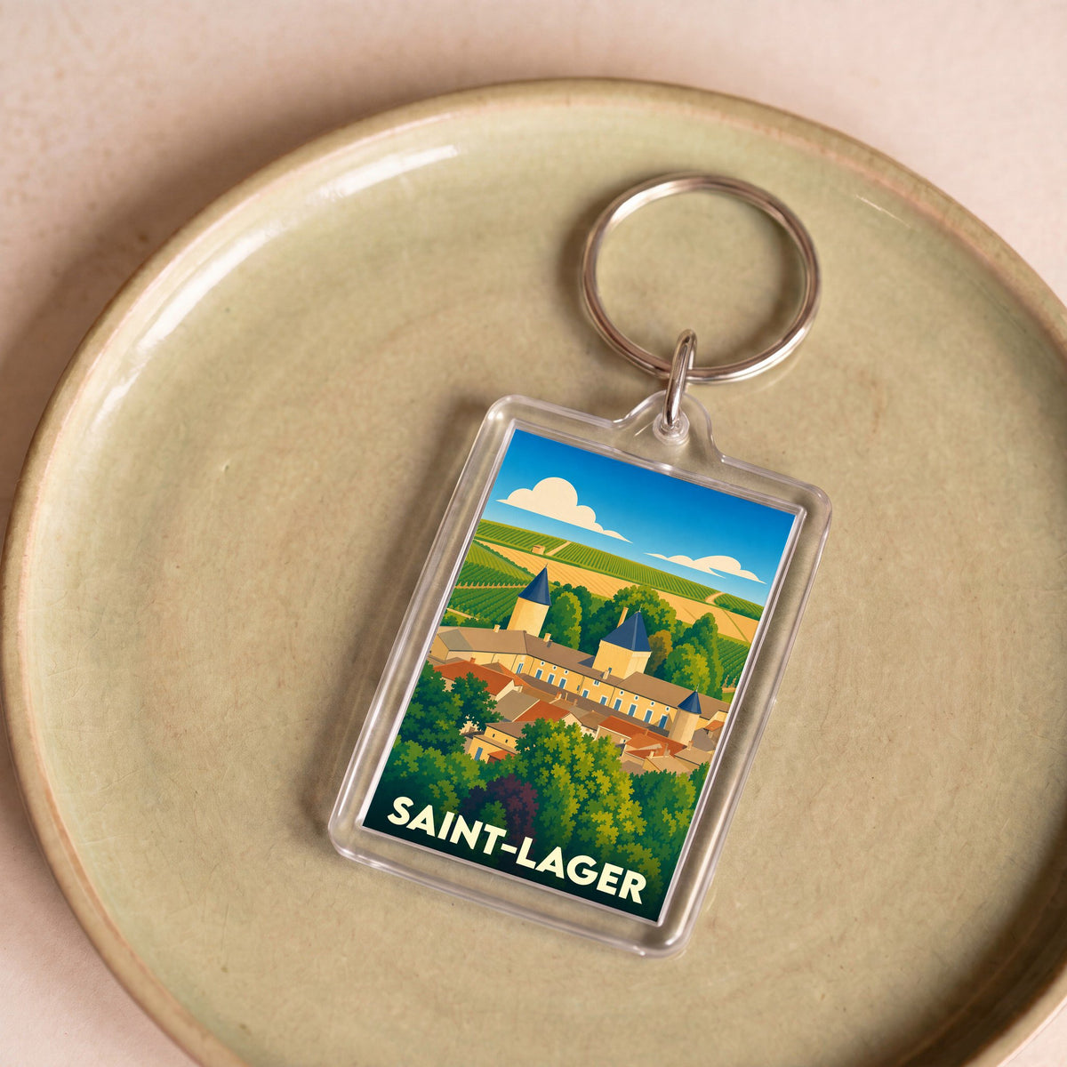 Porte-clés souvenir de la ville de Saint-Lager avec une illustration stylisée.