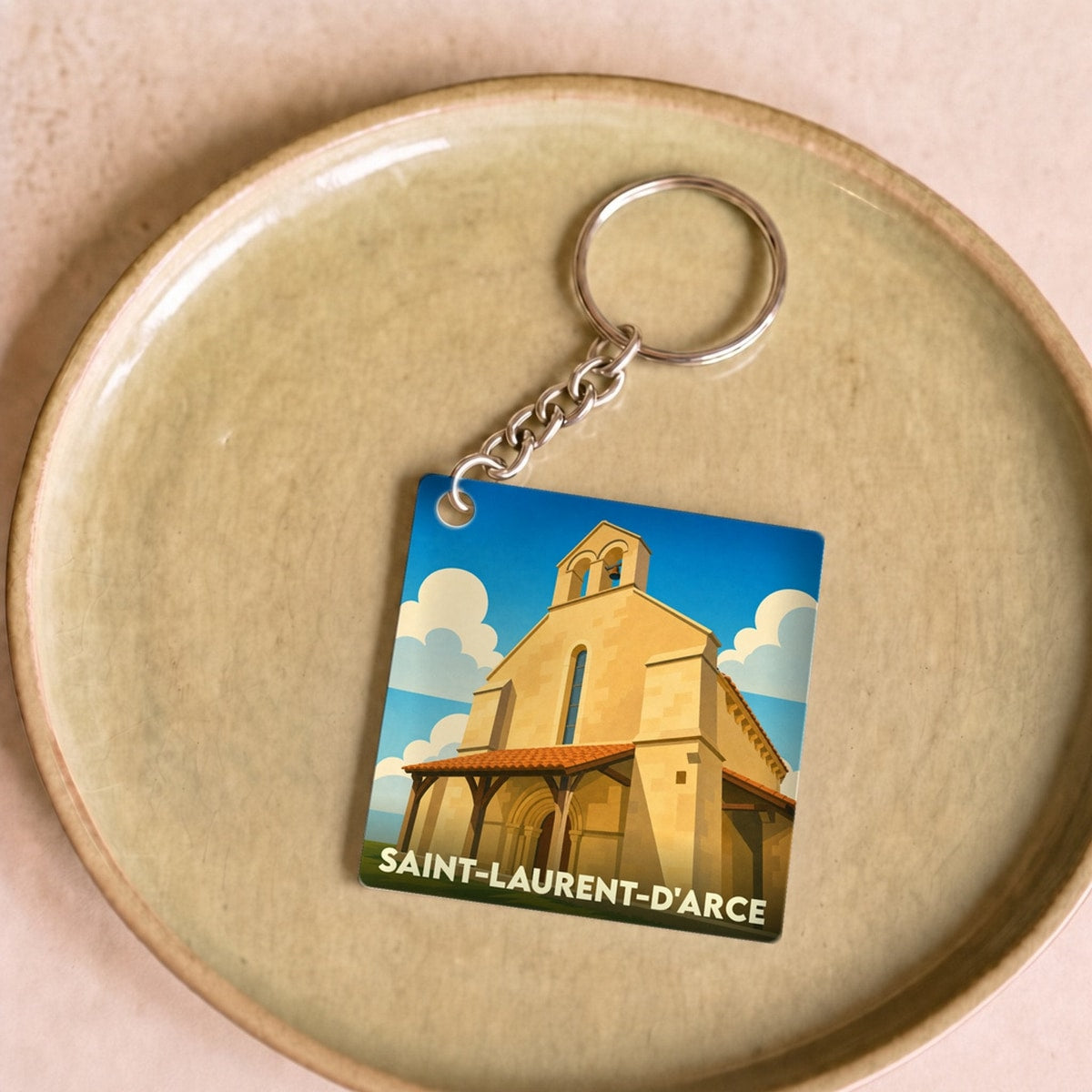 Porte-clés souvenir de la ville de Saint-Laurent-d'Arce avec une illustration stylisée de son église.
