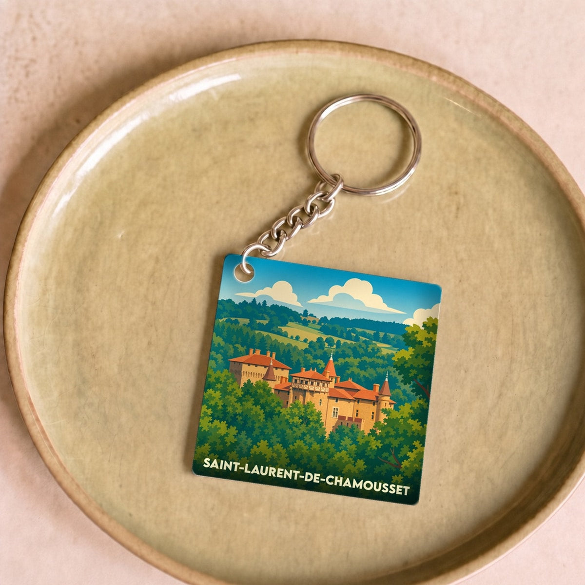 Porte-clés souvenir de la ville de Saint-Laurent-de-Chamousset avec une illustration stylisée de son château.