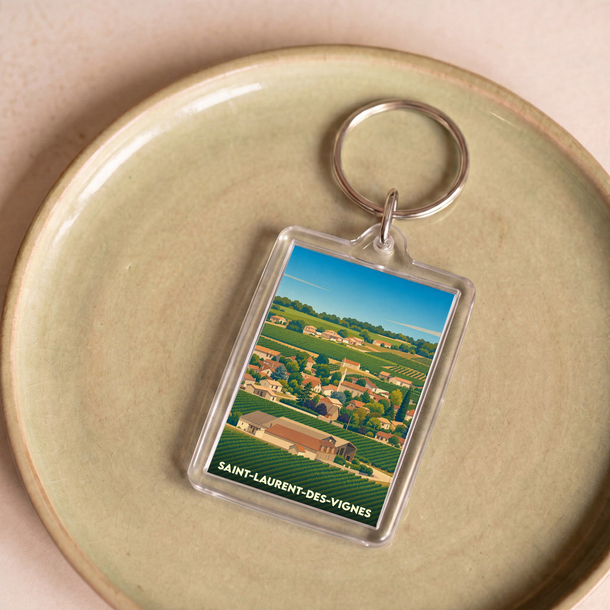 Porte-clés souvenir de la ville de Saint-Laurent-des-Vignes avec une illustration stylisée de ses vignobles.