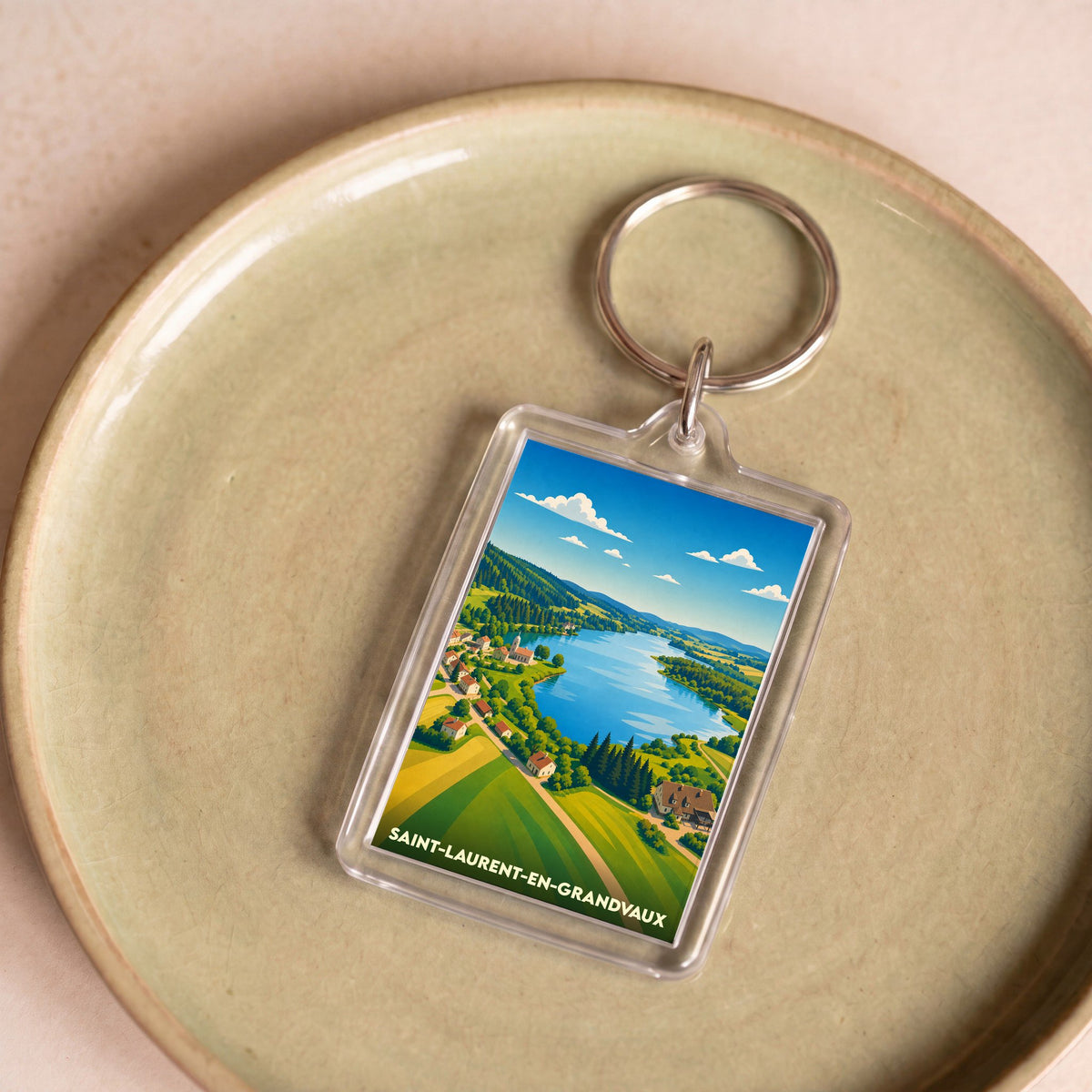Porte-clés souvenir de Saint-Laurent-en-Grandvaux avec une illustration stylisée de son paysage lacustre.
