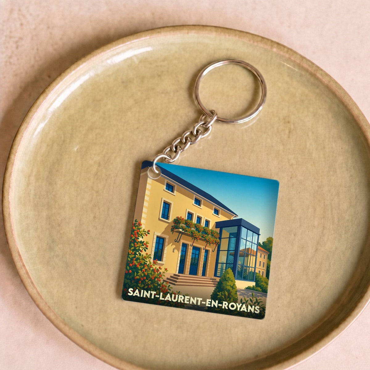 Porte-clés souvenir de la ville de Saint-Laurent-en-Royans avec une illustration stylisée d'un bâtiment.