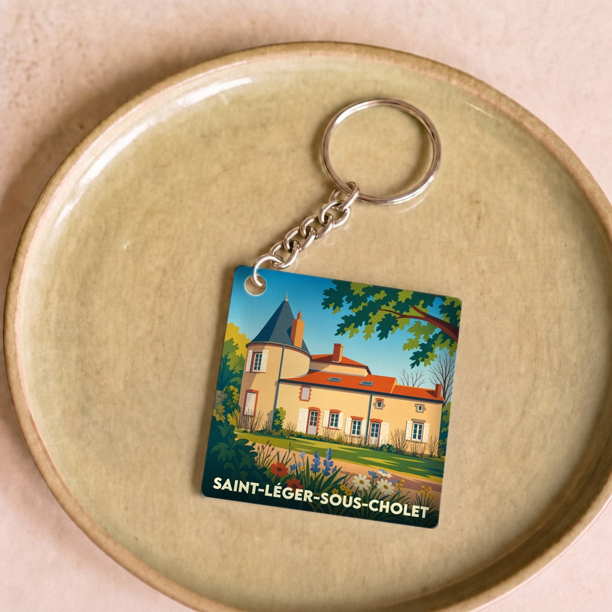 Porte-clés souvenir de la ville de Saint-Léger-sous-Cholet avec une illustration stylisée d'un château.