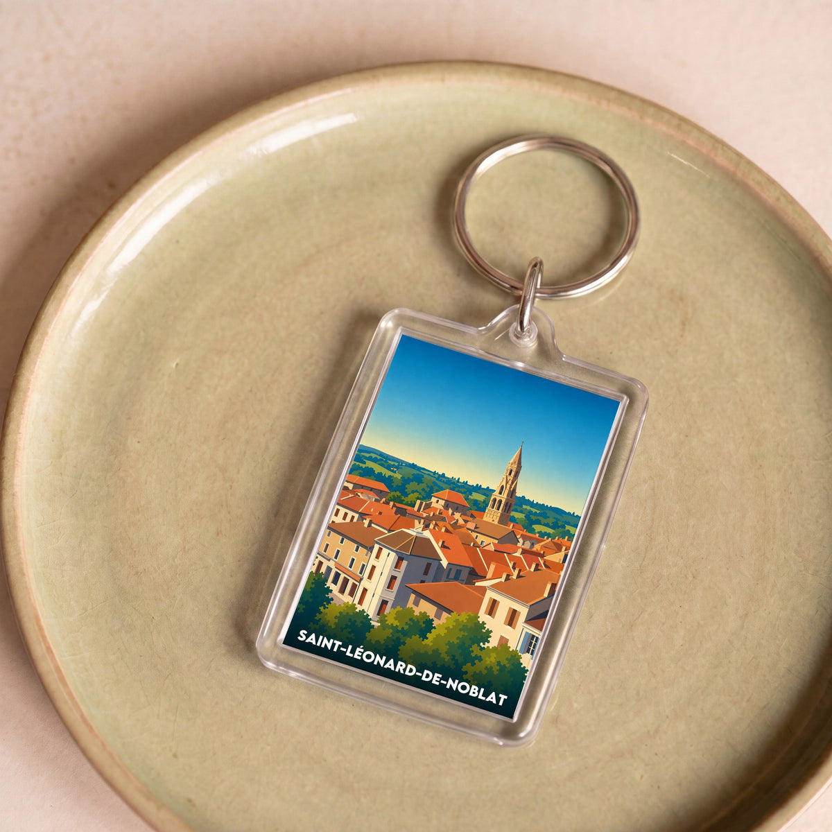 Porte-clés souvenir de la ville de Saint-Léonard-de-Noblat avec une illustration stylisée.