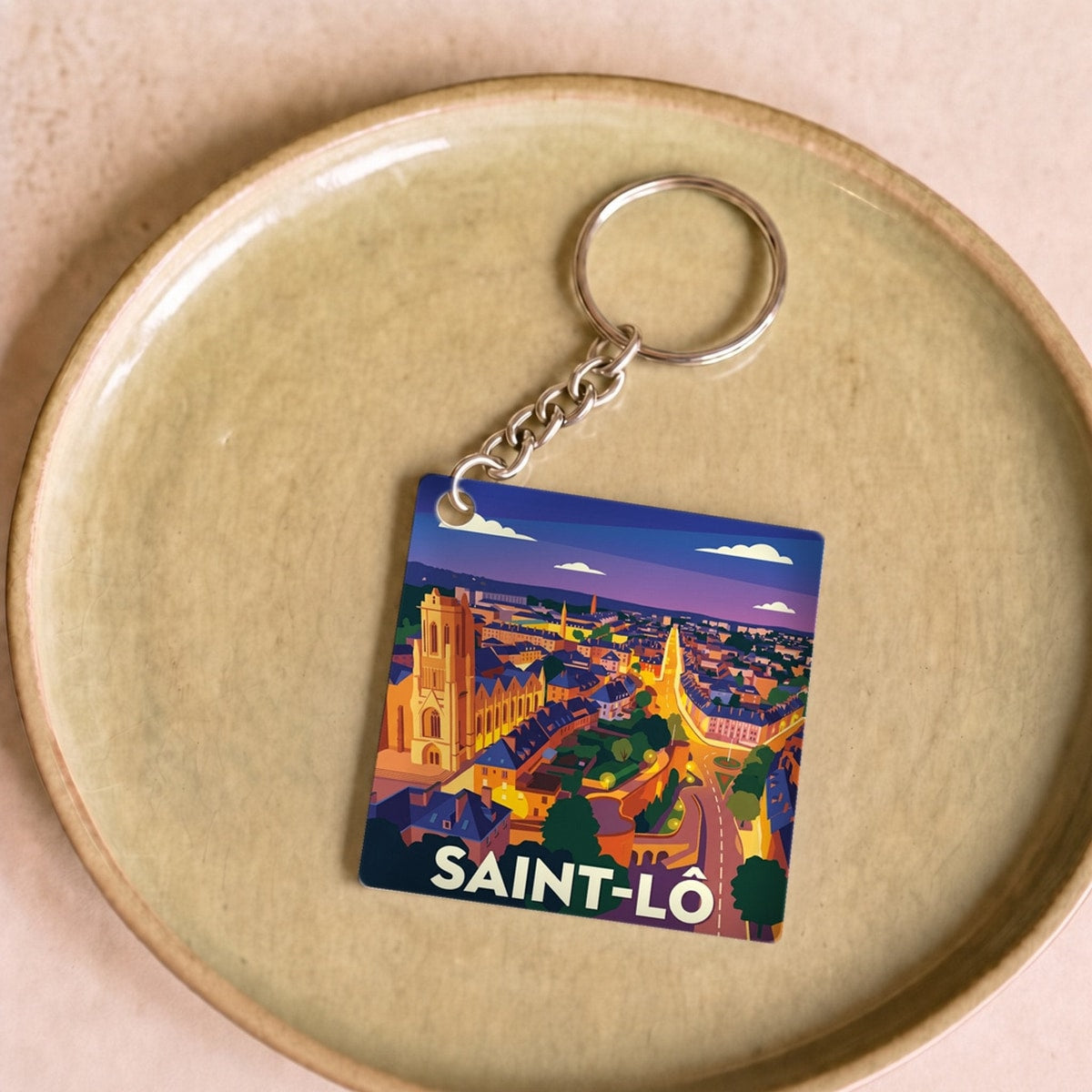 Porte-clés souvenir de la ville de Saint-Lô avec une illustration stylisée.