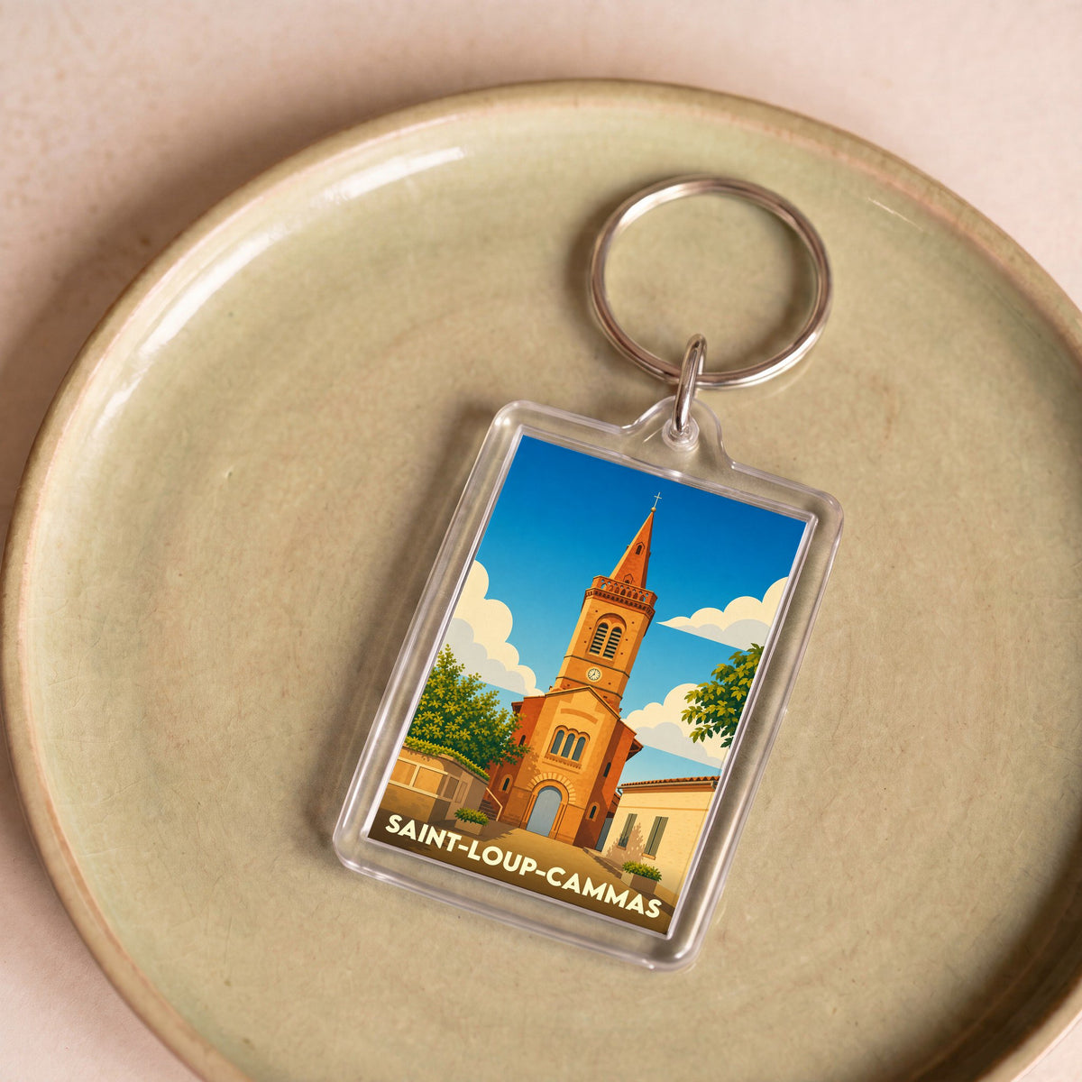 Porte-clés souvenir de la ville de Saint-Loup-Cammas avec une illustration stylisée de son église.
