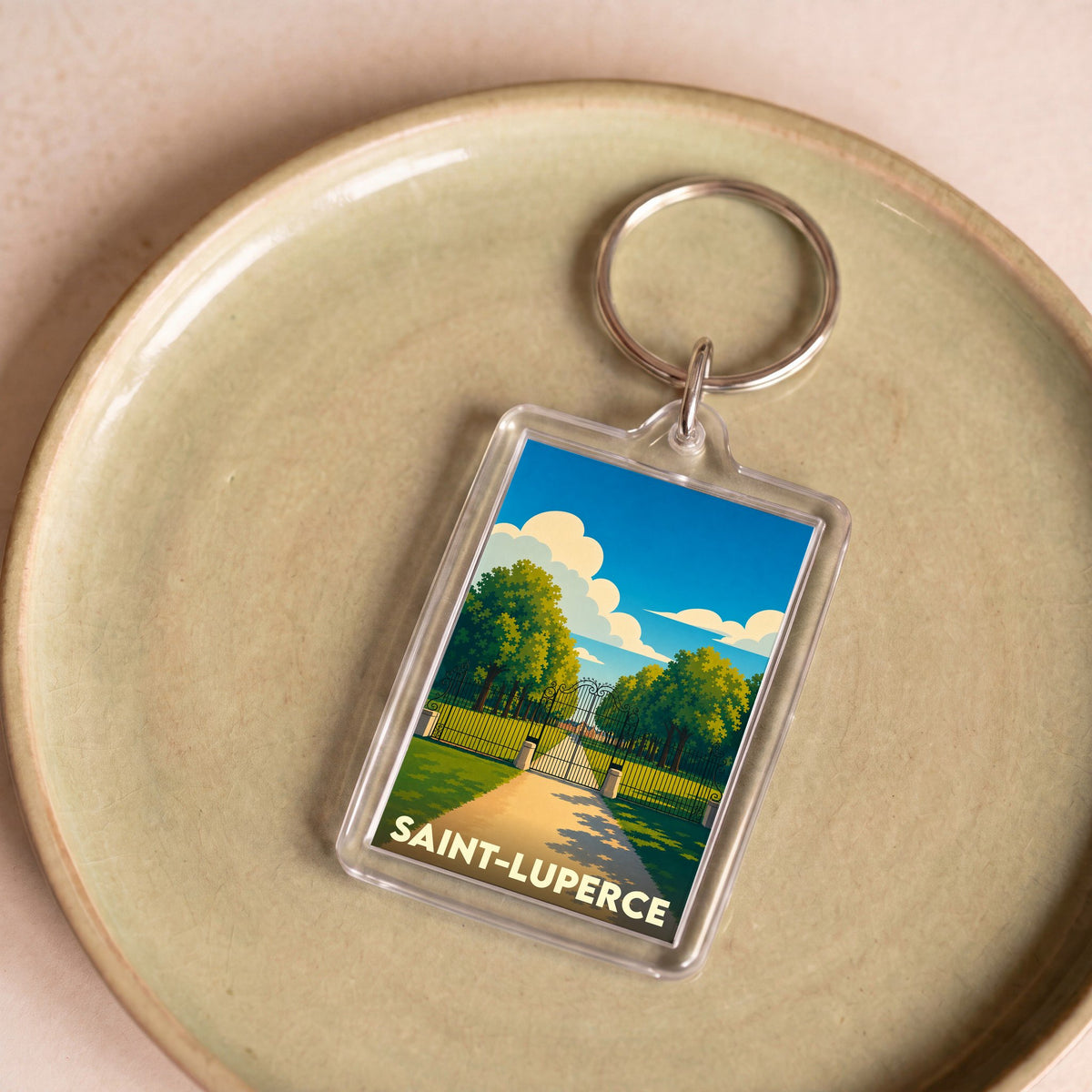 Porte-clés souvenir de la ville de Saint-Luperce avec une illustration stylisée d'un parc.