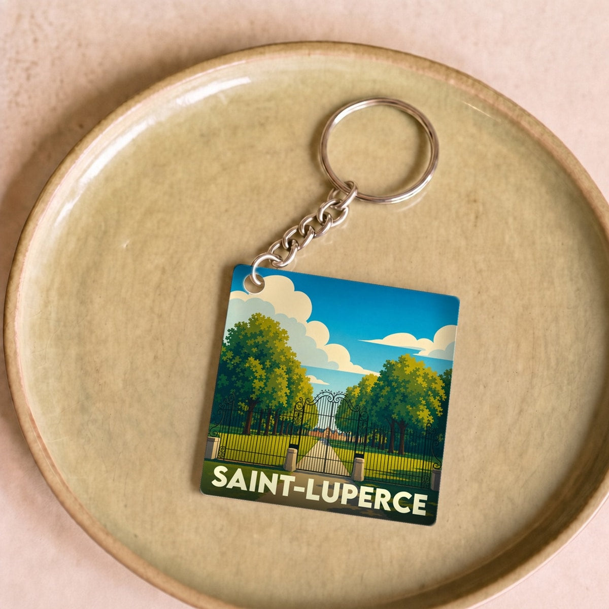 Porte-clés souvenir de la ville de Saint-Luperce avec une illustration stylisée d'un parc.